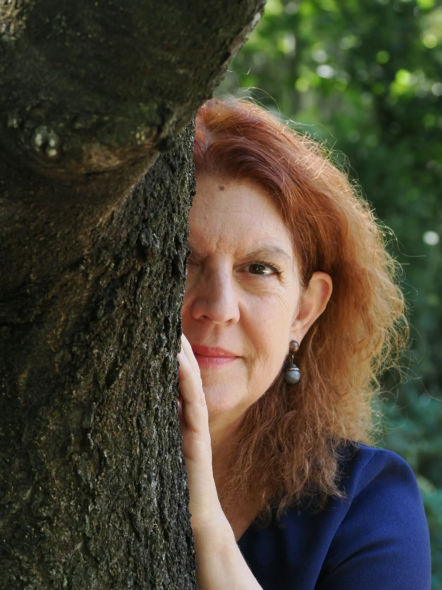 Christine cachée derrière un arbre